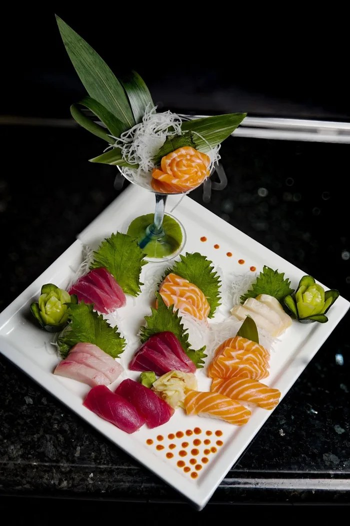 Chef's sushi board with nigiri, uni, and citrus at Kasai